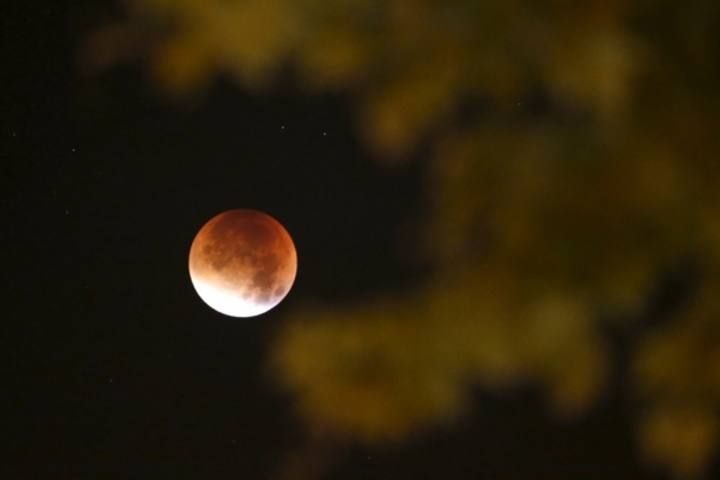 The Moon, appearing in a dim red colour, is covered by the Earth's shadow during a total lunar eclipse over Paris