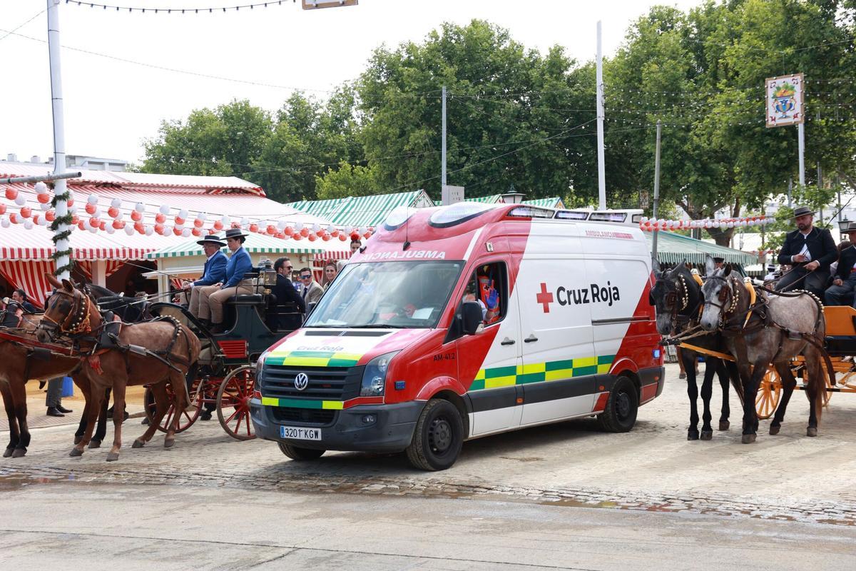 Una ambulancia de la Cruz Roja por el Real de la Feria de Abril de Sevilla.