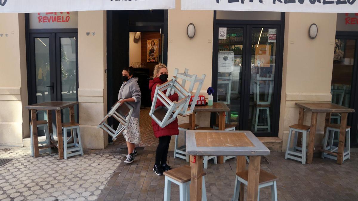 Empleadas de un bar recogen la terraza.