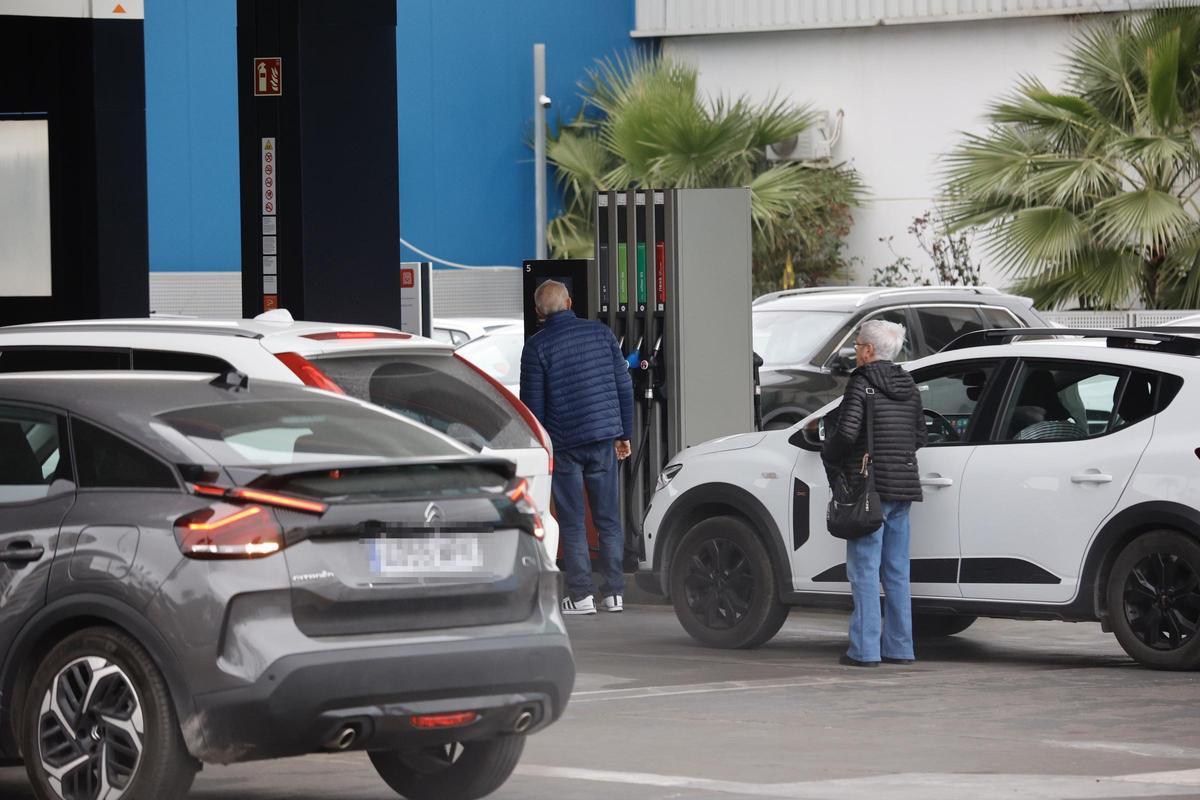 Conductores repostando este lunes en una gasolinera de la ciudad de Murcia con colas de coches.