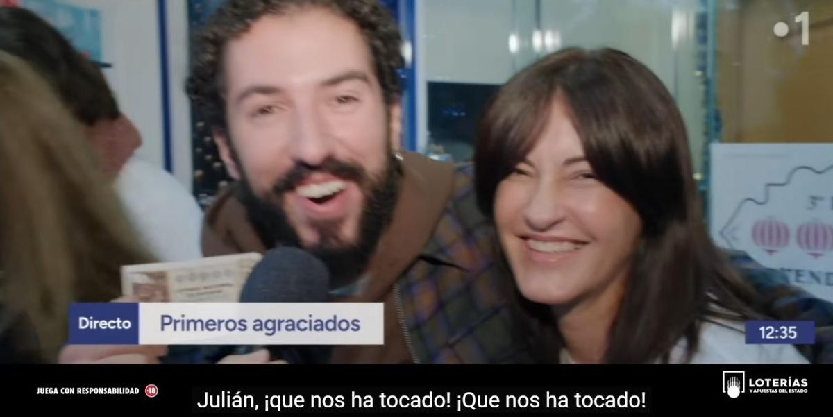 Un joven abraza a la propietaria de la Administración de Lotería nº 32 de Vigo, en la Praza da Miñoca. Anuncio Lotería Navidad 2024
