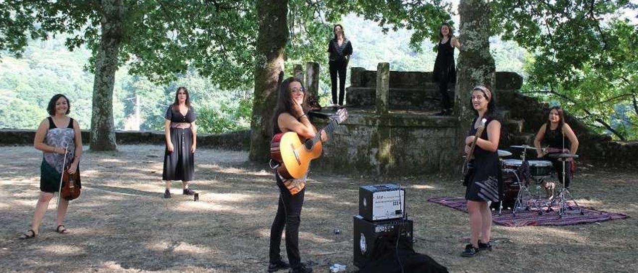 A Banda da Loba con dos bailadoras, en la grabación de &quot;Pepa&quot; en la carballeira de la capilla de A Grela.