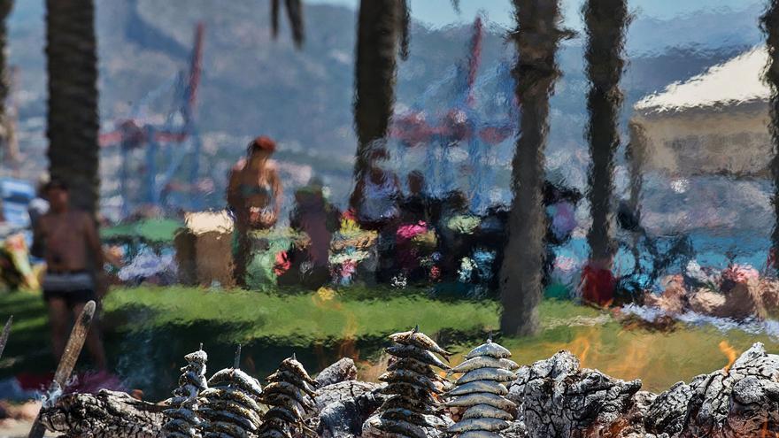 Imagen de una playa de Málaga con los espetos de un chiringuito en primer término.