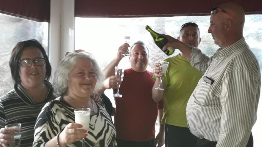 Varias personas celebran en un bar de La Romana el reparto de diez décimos del primer premio de la Lotería de hoy.