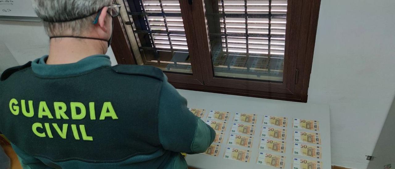 Un guardia civil examina los billetes intervenidos en Cala d’Or.