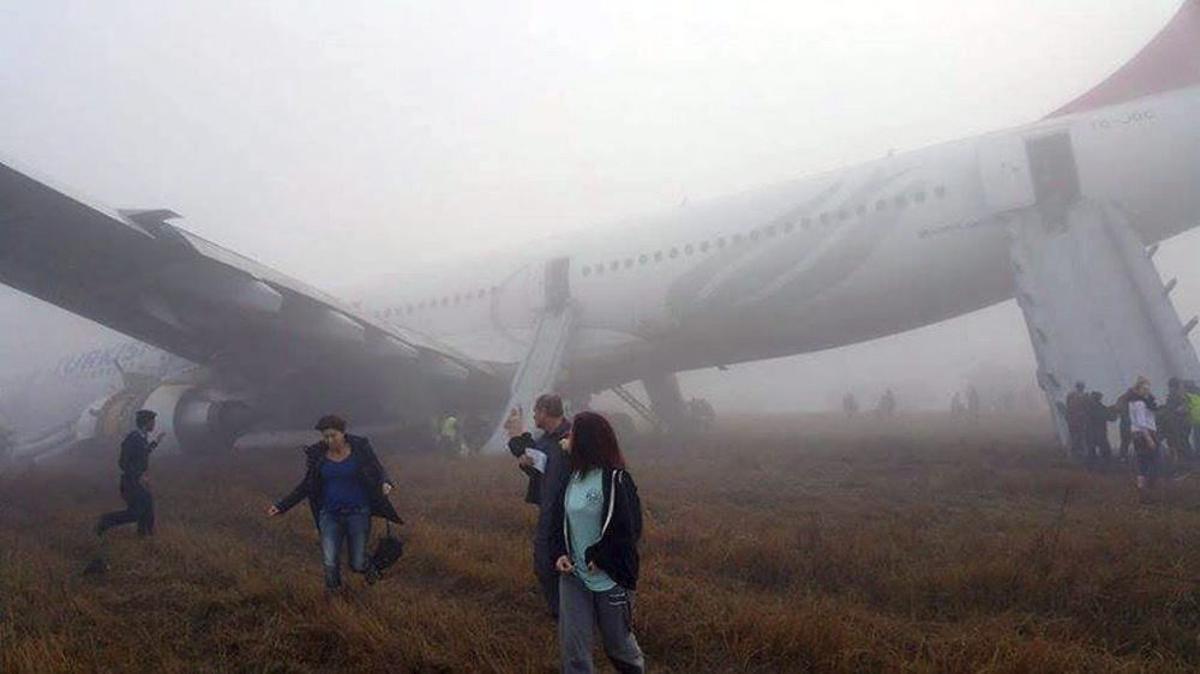 Evacuación de los pasajeros del avión que se ha salido de la pista en el aeropuerto de Katmandú.