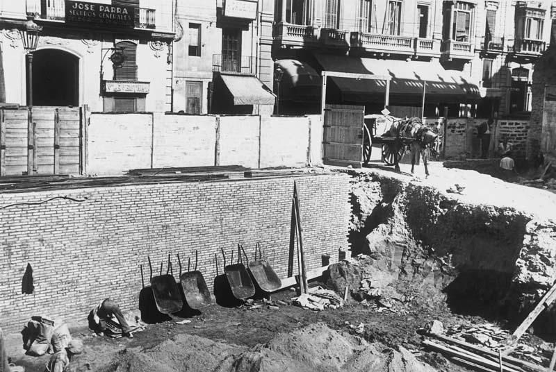 Los operarios del acero   Las 45 fotografías  realizadas entre 1935 y 1936, permiten conocer los métodos de construcción de la época, los materiales utilizados (cemento y acero, principalmente), los medios de transporte (carretas tiradas por burros) o las condiciones laborales de los trabajadores, que no disponían de grandes medidas de seguridad (sin casco, por ejemplo) y vestían con ropa de calle. Las fotografías de esta página muestran los trabajos en el sótano del edificio.