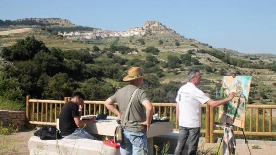 Pintores junto a una panorámica del municipio.