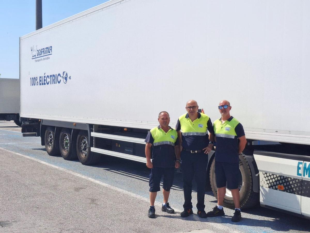 Tres trabajadores de Disfrimur junto a uno de los vehículos eléctricos.