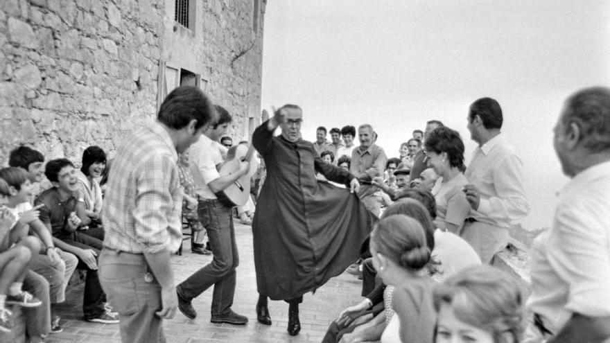 Un grup de gent amb el capellà cantant i ballant en un aplec del 1970