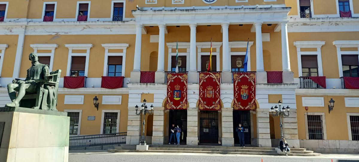 Fachada del palacio municipal en una foto de abril, con el antiguo color y los desconchones y humedades.