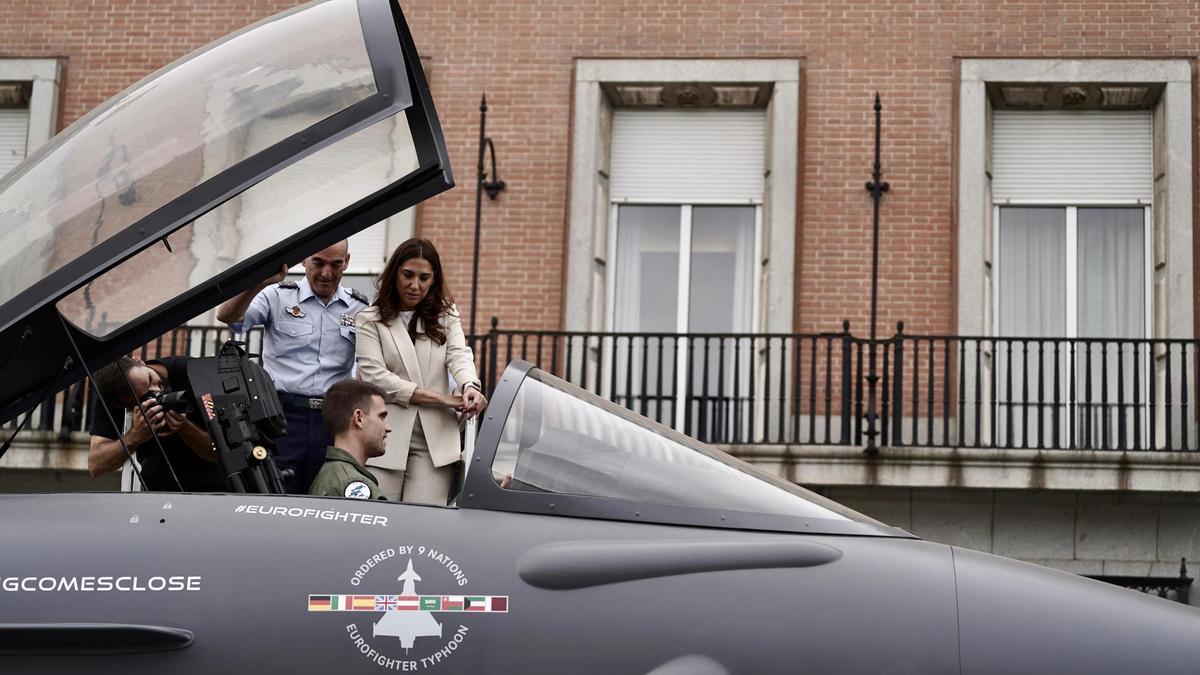 Marta Nogueira, dirctiva de Airbus, y el general Alejandro Chueca se asoman a la cabina del caza Eurofighter que se expone en el cuartel general del Ejército del Aire