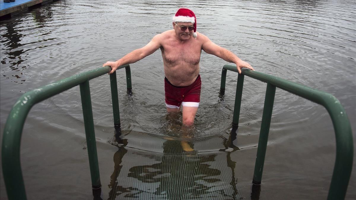 Un hombre sale de un baño en las aguas del Lago Serpentine en Hyde Park durante el baño anual de Navidad en el centro de Londres. 