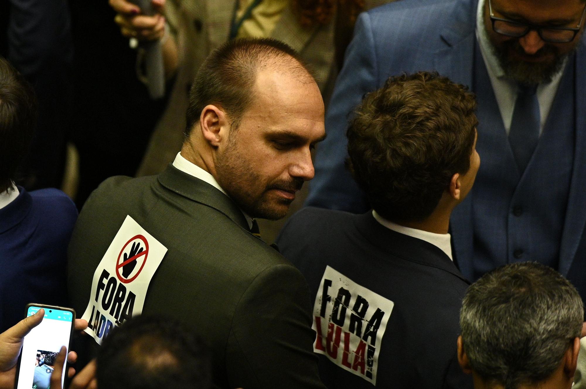 El diputado Eduardo Bolsonaro, hijo del expresidente Jair Bolsonaro, y otro diputado de la ultraderecha con carteles contra Lula en la apertura del Congreso Nacional, este miércoles en Brasilia.