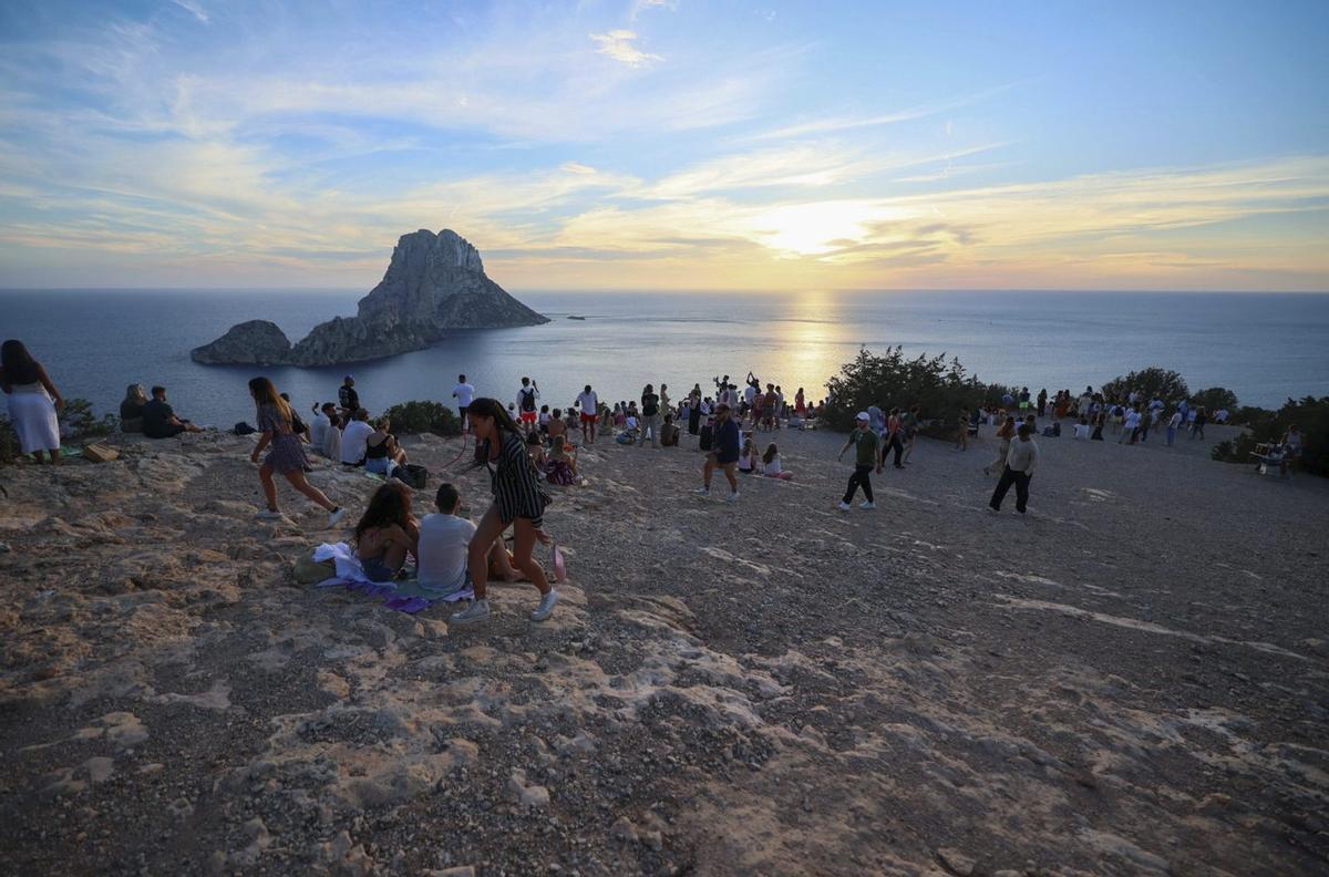 Turistas asisten al ocaso en el mirador de Cala d’Hort. / MARCELO SASTRE