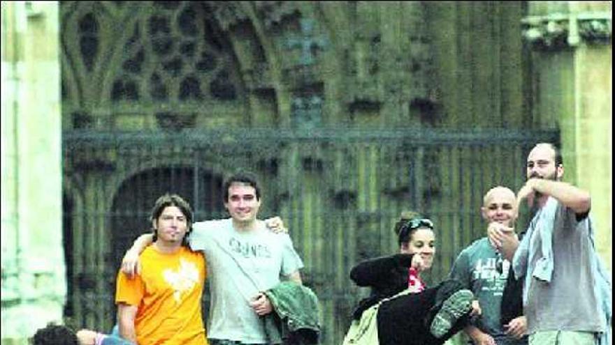 Varios turistas se fotografían ante la catedral de Oviedo.