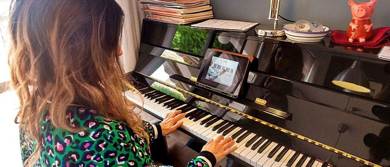 Una mujer recibe clases de piano por internet.