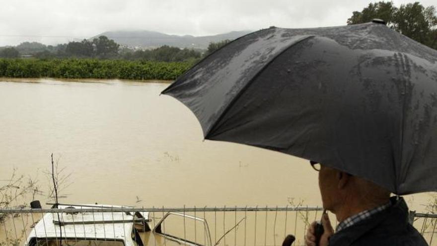 Un hombre observa una parcela inundada tras la subida del río Guadalhorce en Cártama.