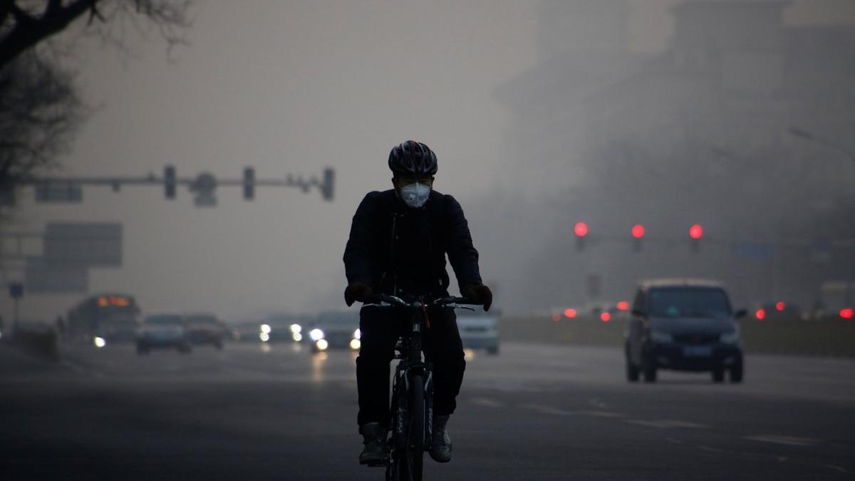 Un ciclista circula por Pekín en un día de alta contaminación.