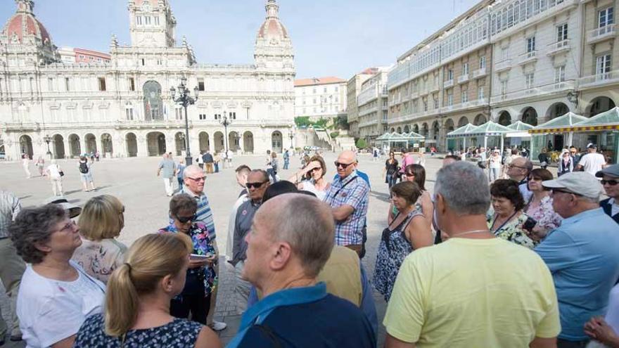 Un grupo de turistas durante una visita a la plaza de María Pita.