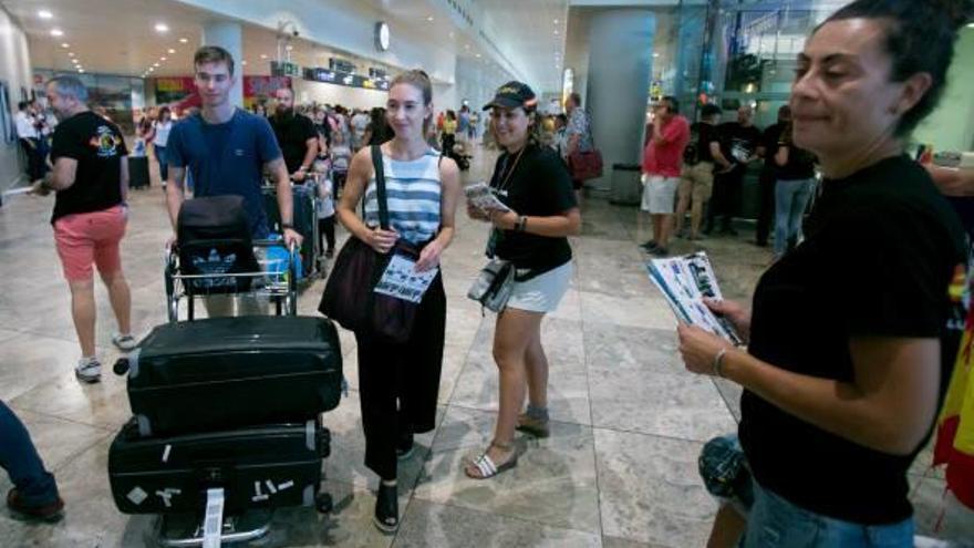 Miembros de la asociación Jusapol informan a los turistas del aeropuerto de El Altet sobre la situación laboral de los policías.