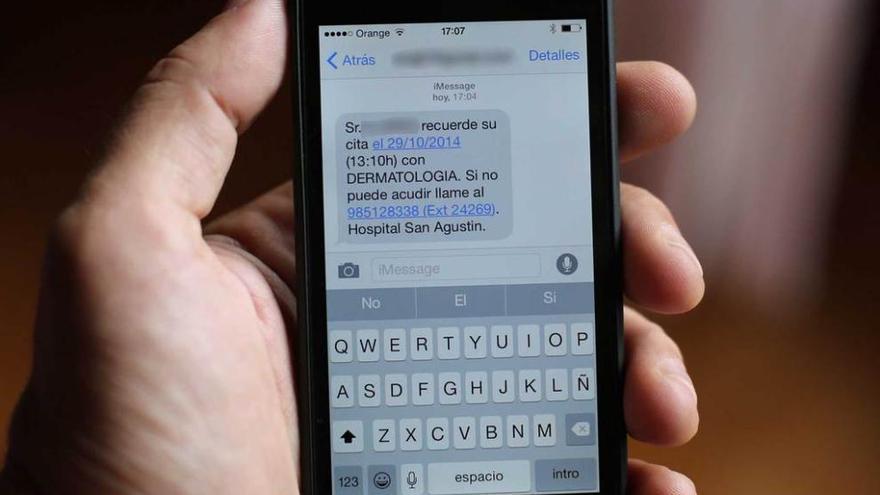 Un paciente muestra un SMS remitido por Gobastur recordándole una cita médica.