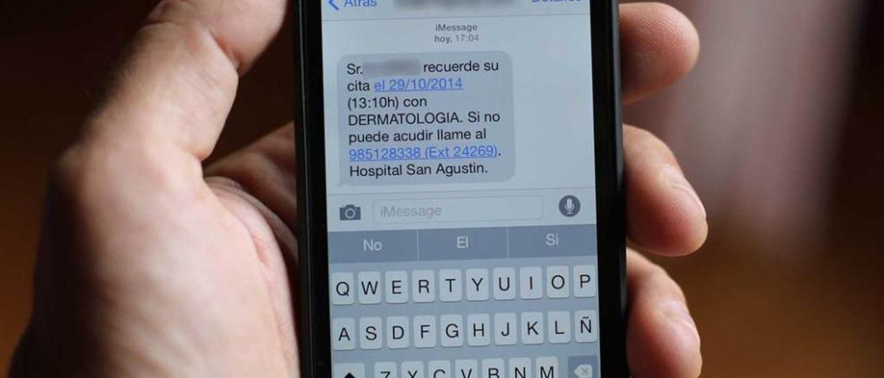 Un paciente muestra un SMS remitido por Gobastur recordándole una cita médica.