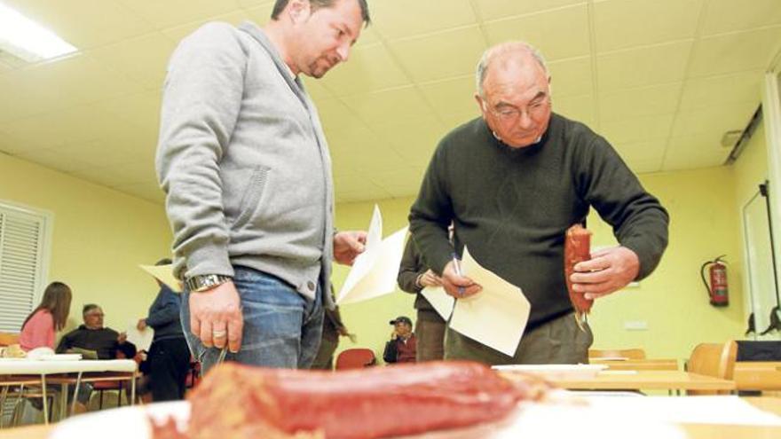 Dos de los catadores analizan una sobrasada antes de probarla.