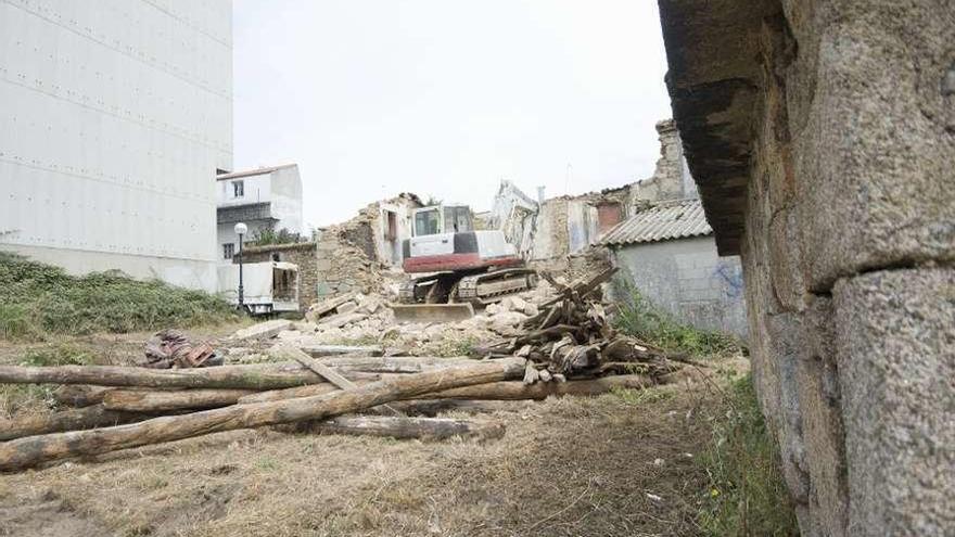 Trabajos de demolición de las casas en ruinas de As Eiras, en Meicende.