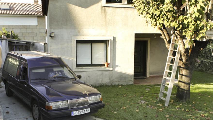 El coche fúnebre traslada el cadáver de una mujer de 39 años que hoy ha sido asesinada presuntamente por su pareja, en el número 56 del Camiño de Breadouro, en la parroquia viguesa de Coruxo.