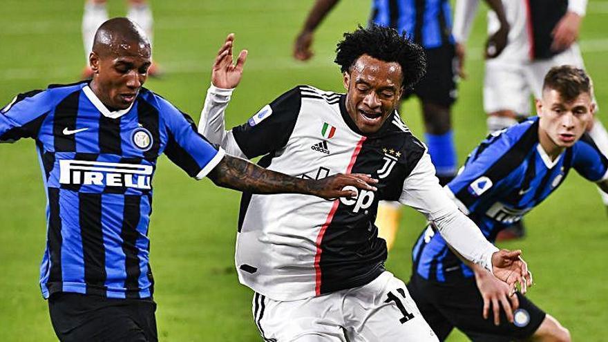 Young y Cuadrado pugnan un balón en el que fue el último partido que se disputó en Italia.