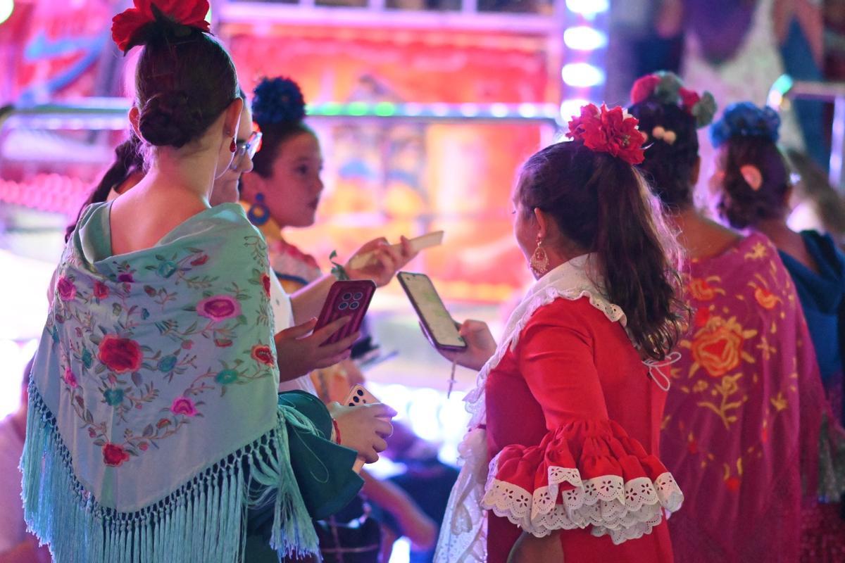 Jóvenes vestidas de flamenca durante la Feria de Baena 2026.