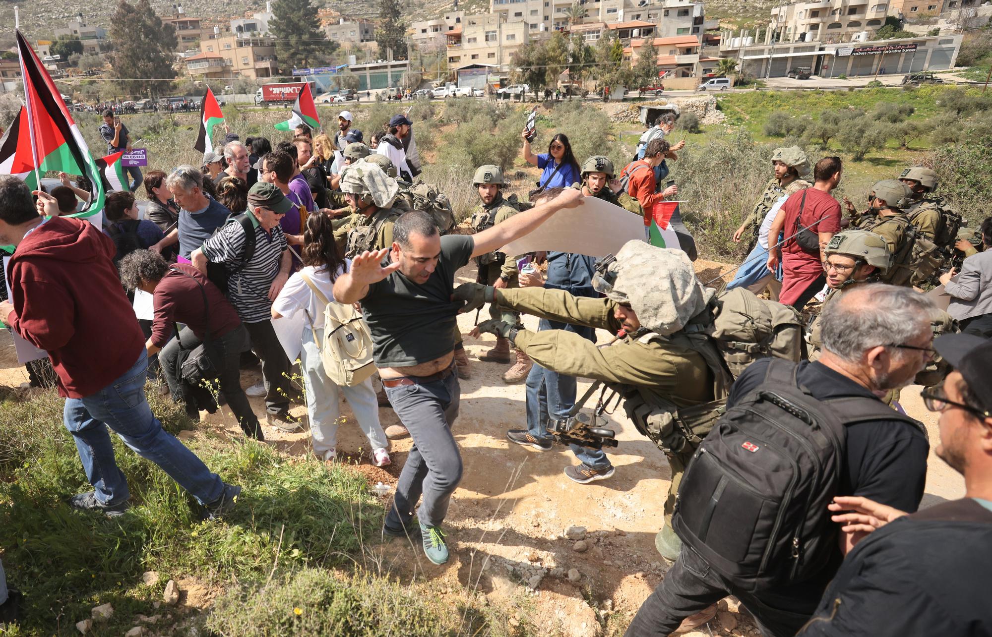 Miembros de las fuerzas de seguridad israelís bloquean a un grupo de activistas la entrada en el pueblo de Hawara, en Cisjordania, este viernes.