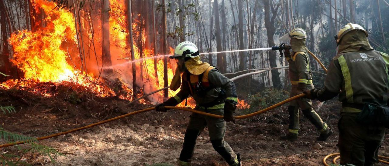 Bomberos apagando el incendio que pasada semana arrasó 82 hectáreas en Arbo. |   // JOSÉ LORES