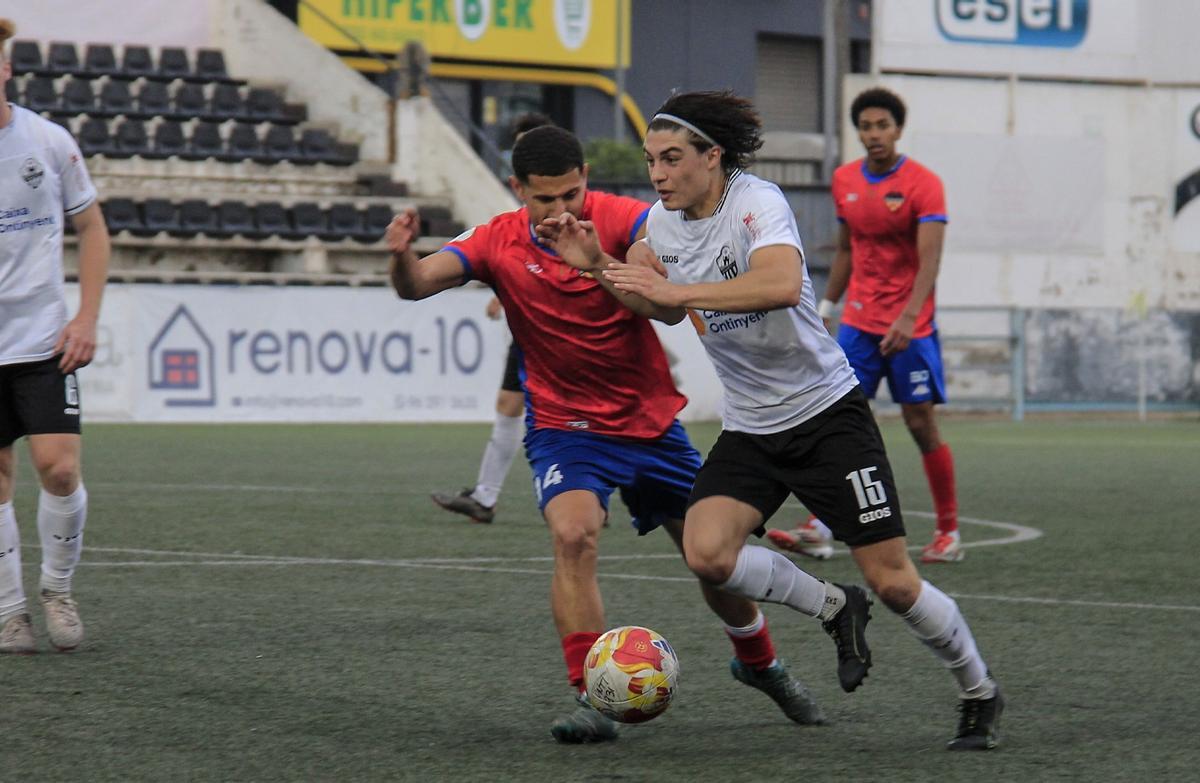 El Ontinyent 1931 conduce el balón ante la presión del Atlético Saguntino, en el partido en el Clariano.