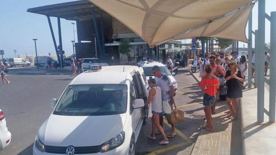 Un grupo de pasajeros coge un taxi en la parada de la estación marítima de la Savina.