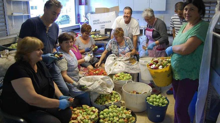 Miembros de la comisión de la Festa da Mazá de Negros, durante la preparación de las manzanas. // FdV