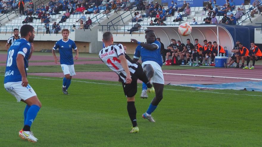 César Díaz disputa el balón ante la presión del futbolista del San Fernando.