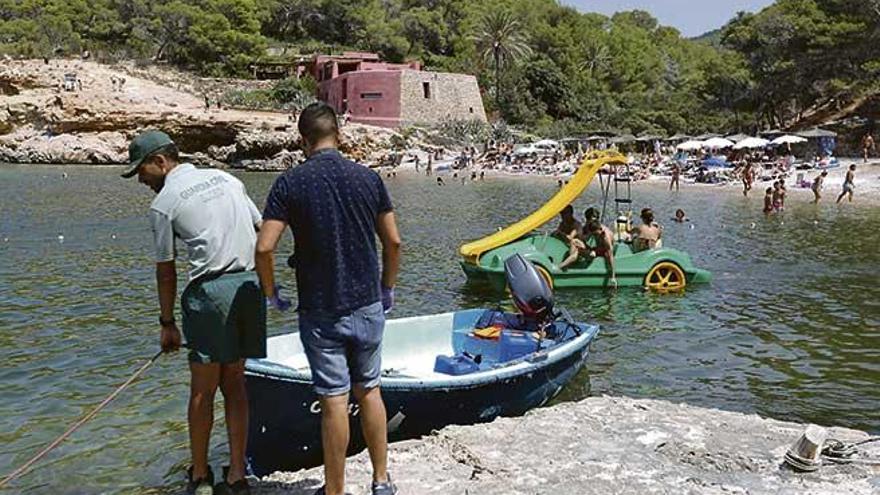 Un agente de la Guardia Civil inspecciona la patera llegada a Cala Salada (Eivissa).