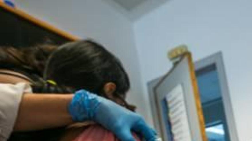 Un enfermero vacuna a una menor.