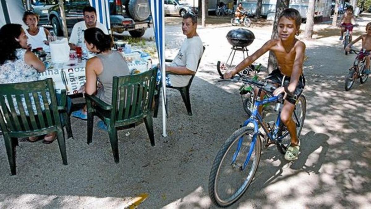 Tres familias de Barcelona apuran sus vacaciones en el camping S'Abanell, de Blanes.