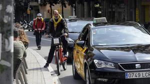 Un ciclista sortea el tráfico en la calle Gran de Gràcia de Barcelona.