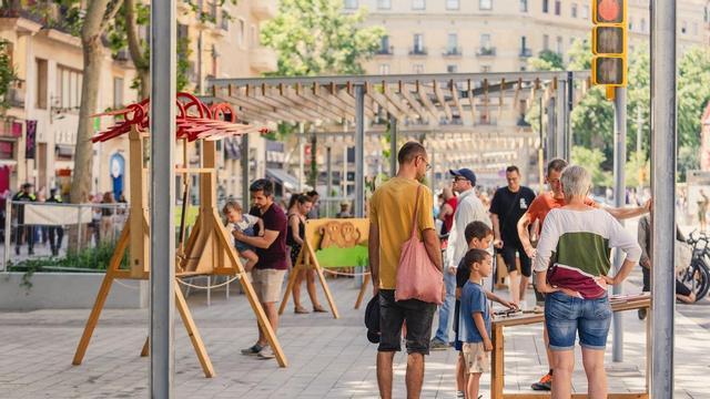 Parque infantil de madera con familias en la inauguración de la ronda de Sant Antoni