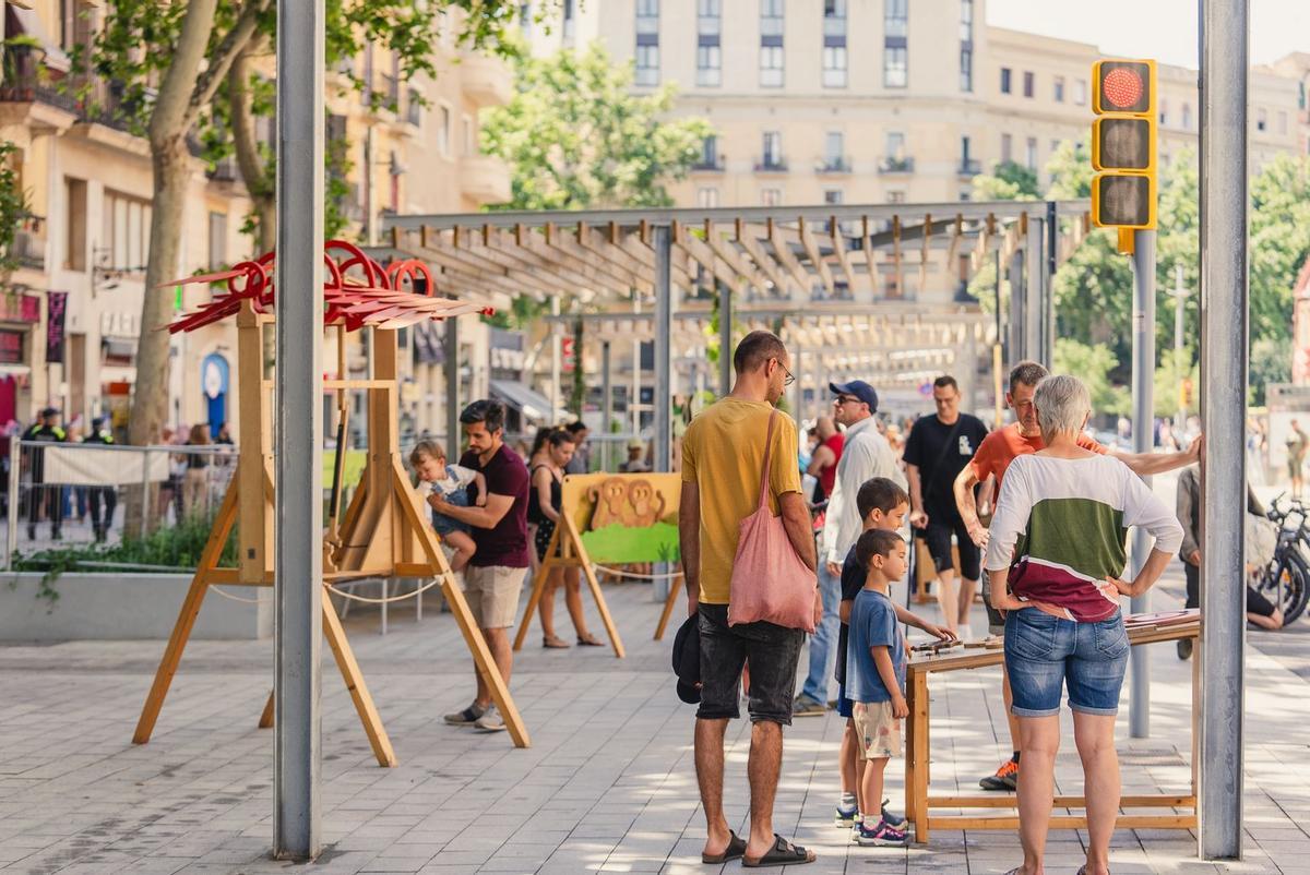 Parque infantil de madera con familias en la inauguración de la ronda de Sant Antoni