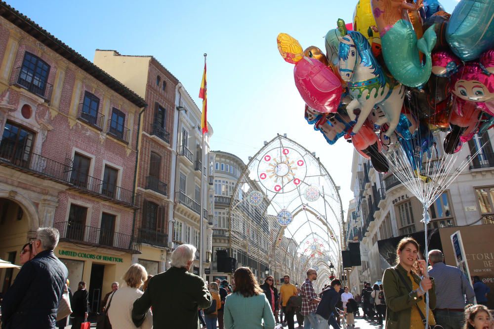 Muchos malagueños y turistas aprovechan el buen tiempo y el día festivo por la Inmaculada Concepción para pasear y realizar las compras navideñas en el Centro de Málaga.