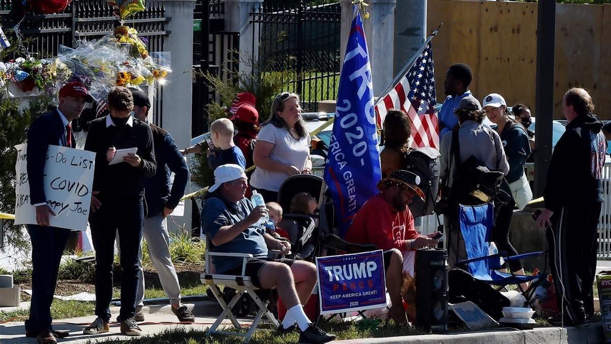 Varios de los seguidores de Trump que montan guardia a las puertas del hospital, este lunes.