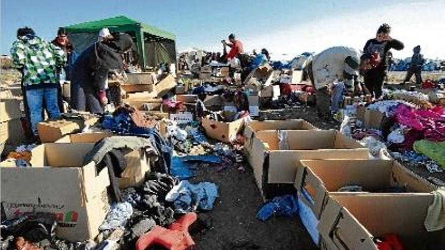 Refugiats sirians, un cop creuada la frontera de Sèrbia amb Hongria, rebusquen roba abandonada.