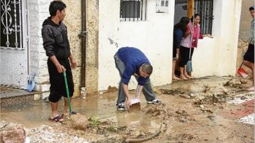 Veïns de Tortosa netejant el carrer després de desbordar-se alguns barrancs.