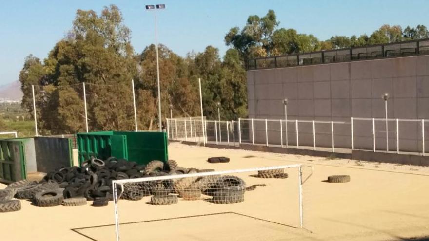 Una imagen facilitada hoy por el PSOE de los neumáticos apilados en la instalación deportiva junto al instituto