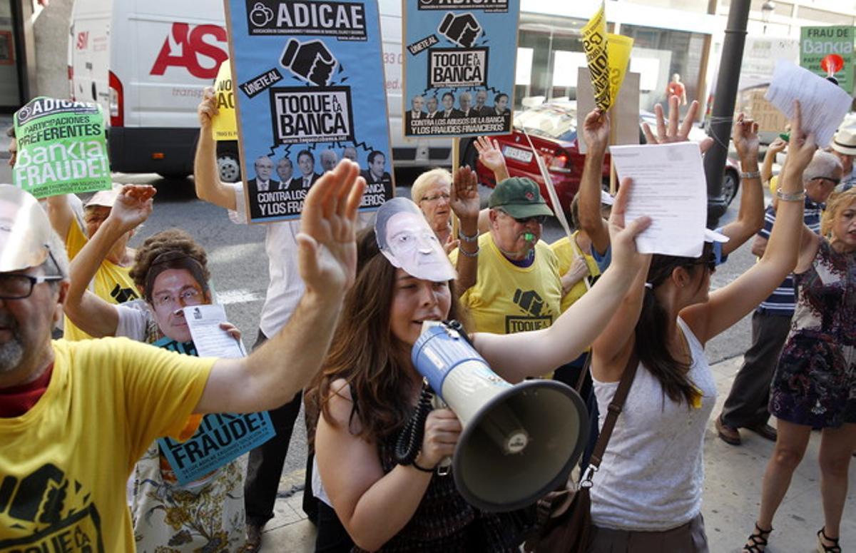 Afectats per les preferents protesten davant la seu de Bankia durant la presentació de resultats de l’entitat, a València. Afectats per les preferents protesten davant la seu de Bankia durant la presentació de resultats de l’entitat, a València.